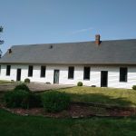 photo de face d'une maison blanche avec de nombreuses menuiseries en pvc gris
